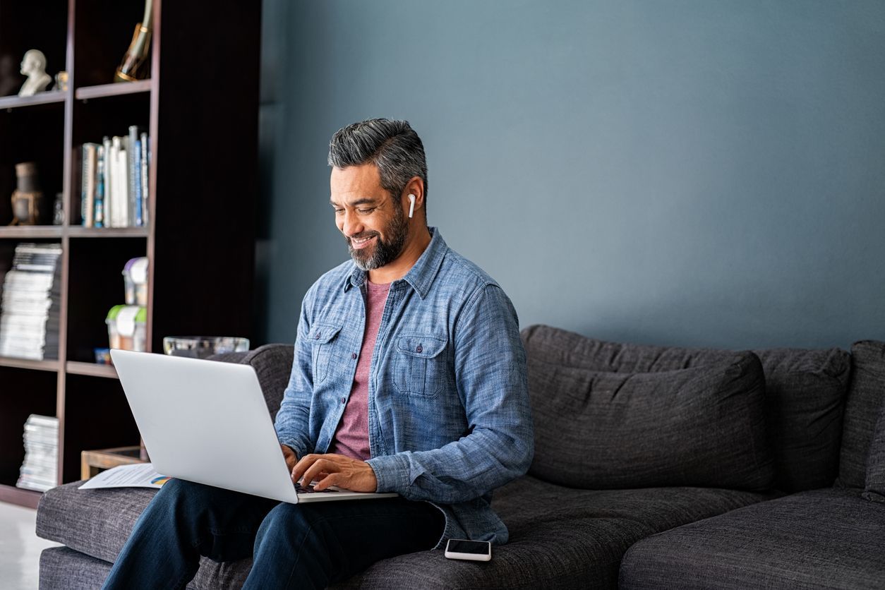 A freelancer working on a laptop from his home office. Discover how much freelancer insurance costs.