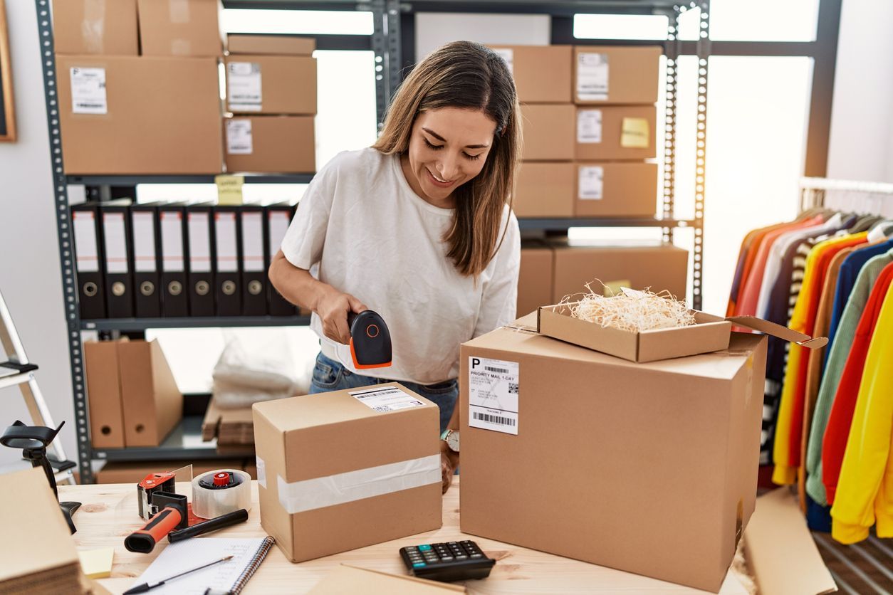 Young woman packing inventory to sell on Amazon. Discover 5 easy steps to start selling on Amazon at the Coverdash blog.